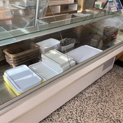 de nombreux plateaux de nourriture exposés derrière une vitrine