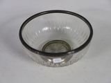 a small glass bowl with a silver rim sitting on a table