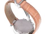 a close up of a watch on a white surface with a brown strap