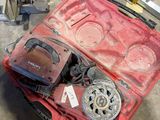 une mallette rouge contenant des outils, posée par terre