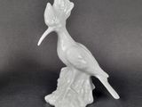 a white bird sitting on top of a tree stump