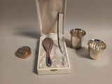 a silver spoon in a box with a spoon in it