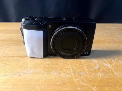 un appareil photo noir et blanc posé sur une table en bois