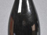 a black bottle with a red top and a yellow label