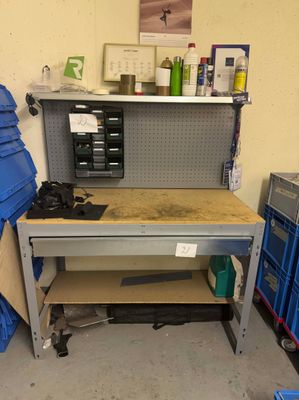 un établi dans un garage, sur lequel sont posés de nombreux outils