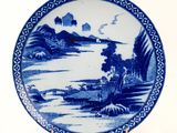 a blue and white plate with a landscape on it