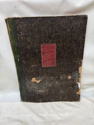 un vieux livre à la couverture rouge posé sur une surface blanche