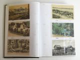 an open book with pictures of a village and a river
