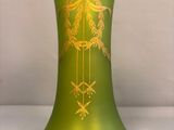 un vase vert orné d'un motif doré