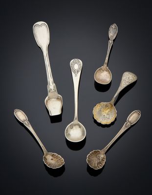 six silver spoons and two silver spoons on a black surface