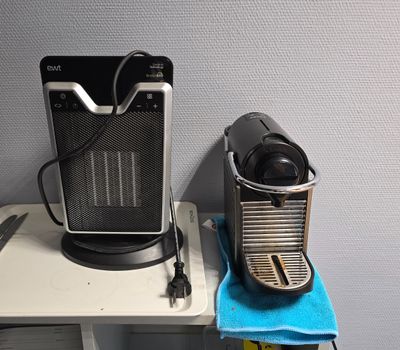une cafetière posée sur une table à côté d'une tasse de café
