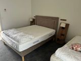 a bed with a white cover and a brown headboard