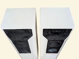 two speakers sitting side by side on a white surface