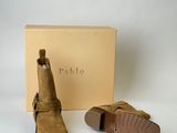 the back of a pair of brown sued ankle boots with a box in the background