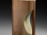 un vase marron orné d'un motif, posé sur une table