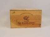 une vieille boîte en bois portant un logo, posée sur une surface blanche