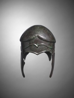 a bronze helmet with horns on a gray background