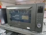 une photo d'un micro-ondes posé sur une étagère dans un magasin