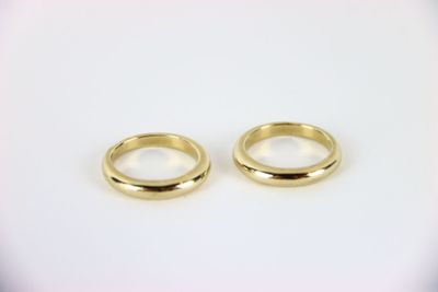 two gold wedding rings on a white background