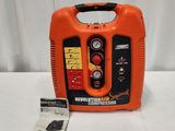 un compresseur d'air portable orange et noir posé sur une table blanche