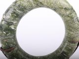 a picture of a green stone ring on a stand