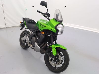 une photo d'une moto verte garée dans une pièce