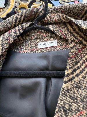 La veste est en laine et possède une doublure en cuir noir
