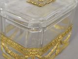 a clear glass box with a gold decoration on it