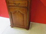 an image of a small wooden cabinet against a red wall