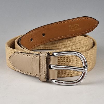 une ceinture munie d'une boucle métallique, posée sur une surface blanche