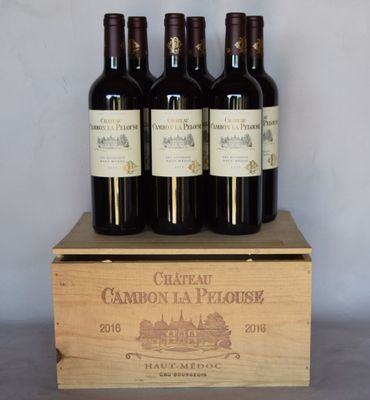 quatre bouteilles de vin rouge dans un coffret en bois posé sur une table