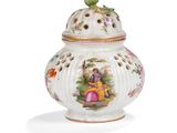 a close up of a white vase with a bird on top of it