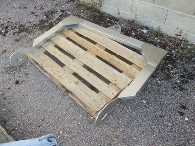 une palette posée par terre à côté d'un bâtiment