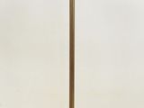 brass plated floor lamp with a glass shade on a stand