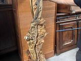 un homme debout à côté d'une croix en bois