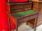 a wooden desk with a green top in a room