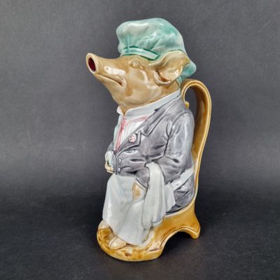 a figurine of a mouse wearing a hat and sitting on a chair