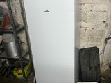 a white refrigerator in a dirty room with a red bottle on top of it