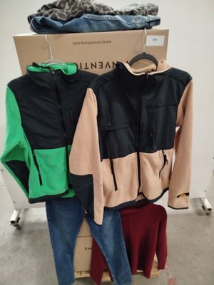 a pile of clothes on a rack in a room