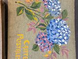 two boxes with flowers painted on them sitting on a table