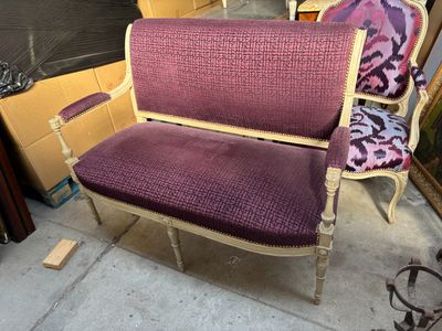 fauteuil rembourré violet devant un tas de bric-à-brac