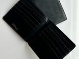 a black wallet and a black wallet on a white surface