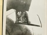 a black and white photo of a dog sitting in the cockpit of a plane