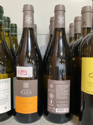 plusieurs bouteilles de vin sont alignées sur une étagère