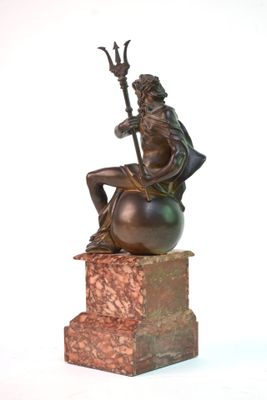 statue représentant un homme assis sur une boule, tenant une lance