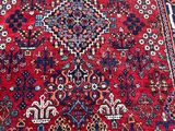 an oriental rug with a red background and a blue border