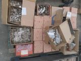 plusieurs cartons contenant divers articles métalliques, posés sur une palette