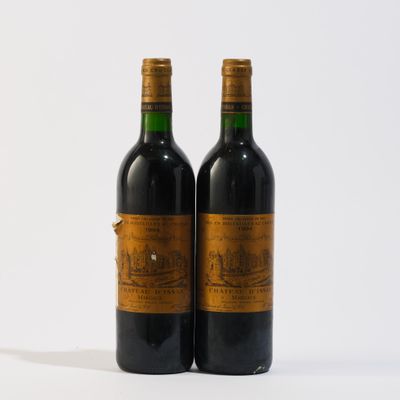 deux bouteilles de vin rouge posées l'une à côté de l'autre sur une surface blanche