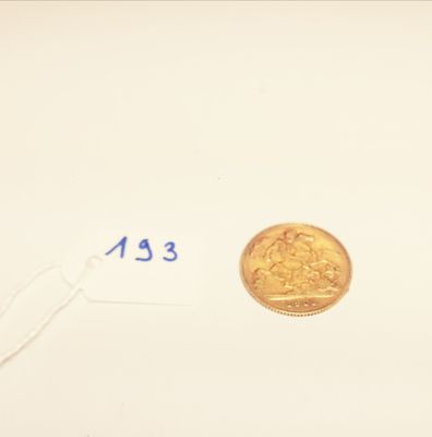a gold coin on a white surface with a price tag on it