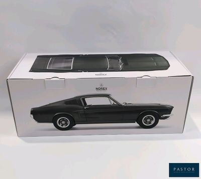 une voiture noire dans une boîte posée sur une surface blanche